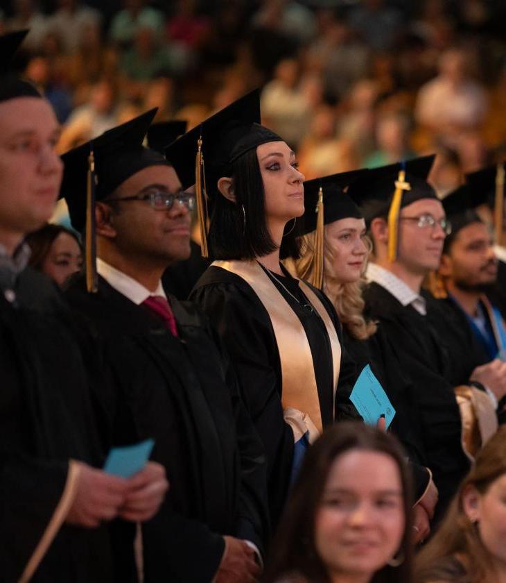 Graduates stand ready to receive their diploma 